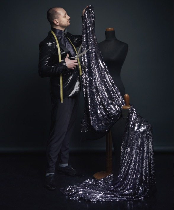 Luca Cristofori nel laboratorio con un tessuto di paillettes